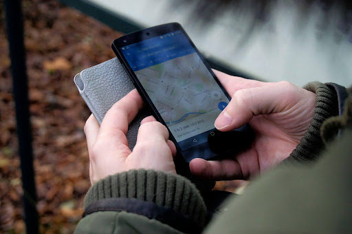 Manos sosteniendo un smartphone con una aplicación de mapas